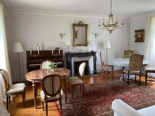 un salon avec une table et une cheminée dans l'établissement Villa Roulage Ferme 18ème Jardin Parking Normandie Plage, à Longueville