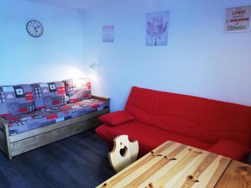 un salon avec un canapé rouge et une table dans l'établissement Résidence Les Hameaux I - Résidence LES HAMEAUX I N°268 MAE-4981, à La Plagne Tarentaise