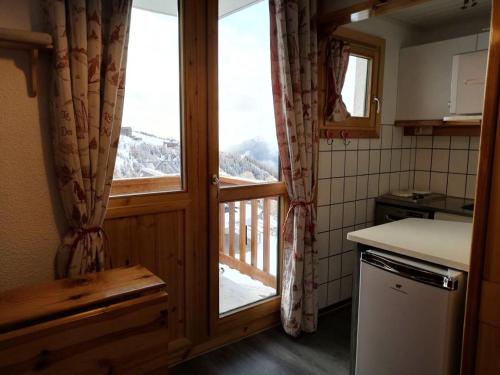 Il comprend une cuisine avec une fenêtre offrant une vue sur la montagne. dans l'établissement Résidence Les Hameaux I - Résidence LES HAMEAUX I N°268 MAE-4981, à La Plagne Tarentaise