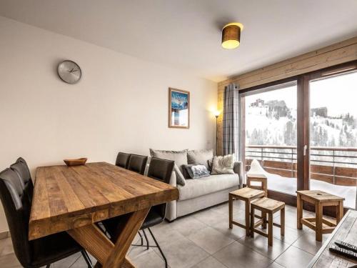 un salon avec une table en bois et un canapé dans l'établissement Résidence Lodges 1970 - Résidence LES LODGES1970 N° A507 MAE-5041, à La Plagne Tarentaise