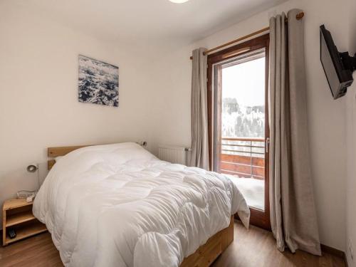 une chambre avec un lit blanc et une fenêtre dans l'établissement Résidence Lodges 1970 - Résidence LES LODGES1970 N° A507 MAE-5041, à La Plagne Tarentaise