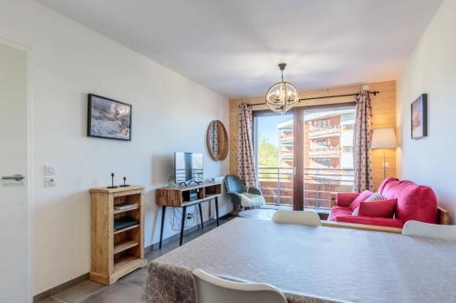 - un salon avec un canapé rouge et un bureau dans l'établissement Résidence Lodges 1970 - Résidence LES LODGES 1970 N° A401 MAE-5061, à La Plagne Tarentaise