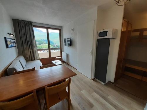 un salon avec une table de salle à manger et une cuisine dans l'établissement Résidence Les Drus - Résidence LES DRUS N°119 MAE-5191, à La Plagne Tarentaise