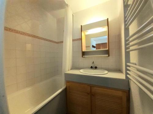 une salle de bain avec un lavabo, un miroir et une baignoire dans l'établissement Résidence Les Drus - Résidence LES DRUS N°119 MAE-5191, à La Plagne Tarentaise