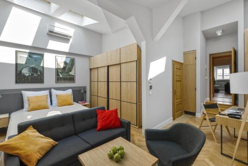 - un salon avec un canapé et un lit dans l'établissement STRADONIA Serviced Apartments, à Cracovie