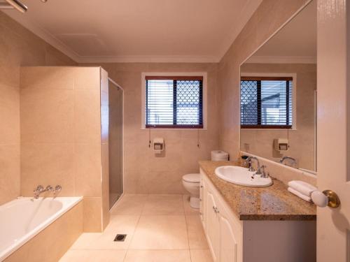 Un baño con bañera, inodoro y lavabo. en River View 5B Home near Freeway Shops Loganholme, en Loganholme