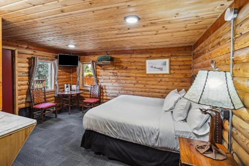 ein Schlafzimmer mit einem Bett und einem Tisch und Stühlen in der Unterkunft Denali Crow's Nest Cabins in McKinley Park