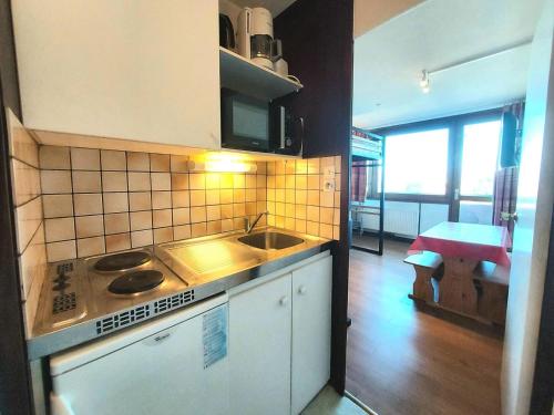 une cuisine avec un évier et une cuisinière four supérieur dans l'établissement Résidence Le France - Résidence LE FRANCE N°114 MAE-5261, à La Plagne Tarentaise