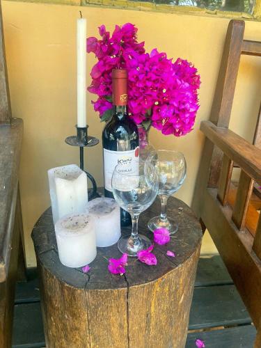 a bottle of wine and candles and flowers on a barrel at Nsobe Game Camp in Masaiti
