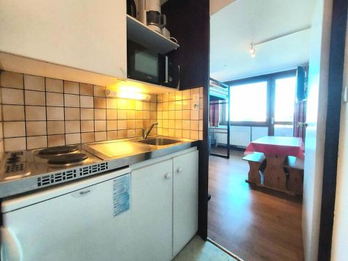 une cuisine avec un évier et une cuisinière four supérieur dans l'établissement Résidence Le France - Résidence LE FRANCE N°114 MAE-5261, à La Plagne Tarentaise