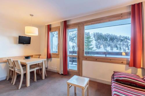 un salon avec une table et une grande fenêtre dans l'établissement Résidence Soldanelle - Résidence SOLDANELLES N°412 MAE-5391, à La Plagne Tarentaise