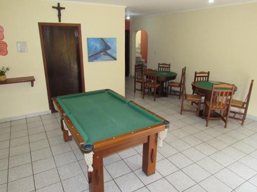 a room with a pool table and tables and chairs at Pousada Casa na Praia in Ubatuba