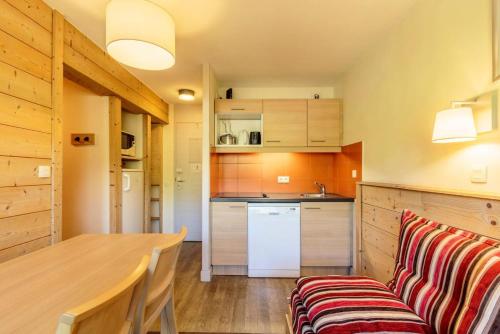 une cuisine avec une table en bois et un canapé dans l'établissement Résidence Sainbois - Résidence SAINBOIS N°233 MAE-5411, à La Plagne Tarentaise