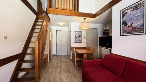 un salon avec un escalier et un canapé rouge dans l'établissement Résidence Le Cervin - Résidence LE CERVIN N°417 MAE-5501, à La Plagne Tarentaise