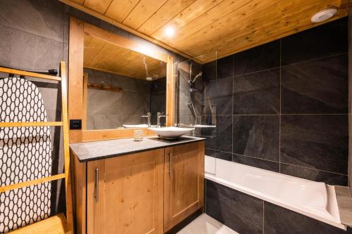 une salle de bain avec un lavabo et une baignoire dans l'établissement Résidence Manaka - Résidence LE MANAKA C06 MAE-5561, à La Plagne Tarentaise