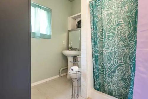 a bathroom with a sink and a shower curtain at Pool Room - Entire Guest Suite - Private Entrance in San Diego