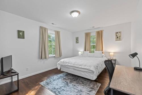 a white bedroom with a bed and a desk at Cozy 1BR 1BA Apartment Near Fort Gregg-Adams in Hopewell