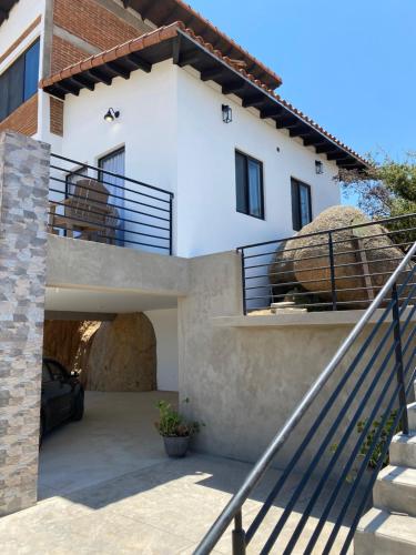 a villa with a staircase leading up to a house at Bonita cabaña en Rancho Tecate resort in La Joya