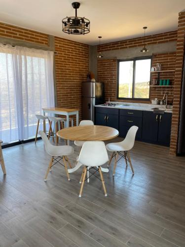 a kitchen with a table and chairs in a kitchen at Bonita cabaña en Rancho Tecate resort in La Joya