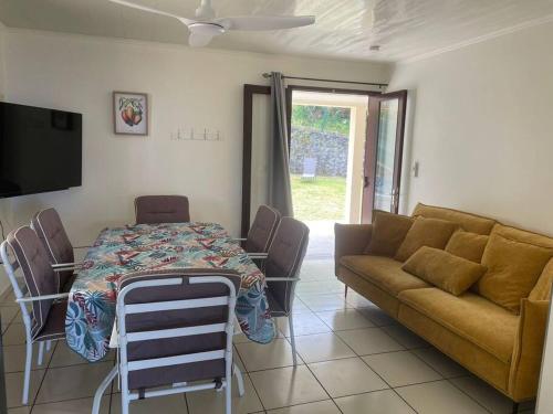 a living room with a table and a couch at Wopé Tremblet ! 3 étoiles in Saint-Philippe