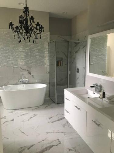 a bathroom with a tub and a sink and a chandelier at Luxury in Spacious Home in Horseshoe Bay