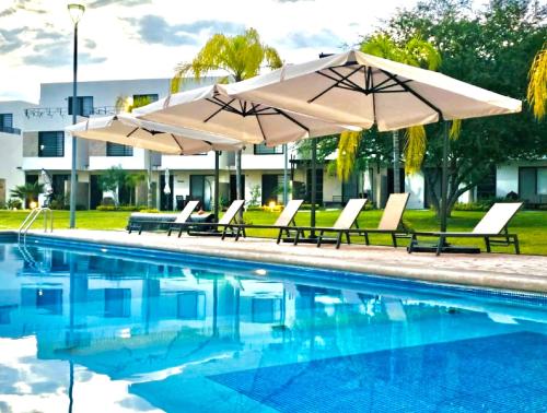a pool with umbrellas and lounge chairs next to it at Aceptamos 1 mascota mini o raza peq selecciona la tarifa CON MASCOTA o paga la tarifa directa al anfitrion in Xochitepec