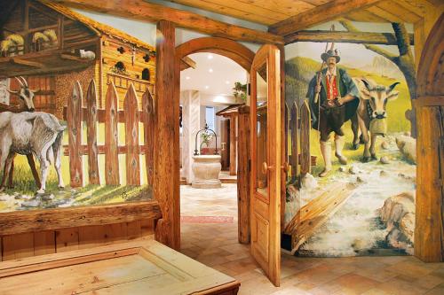 a room with a painting of a man with skis at Hotel Diamant Park in Campitello di Fassa