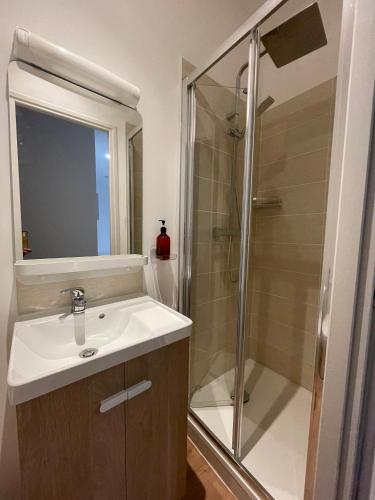 une salle de bain avec un lavabo et une douche dans l'établissement Edenly Stay, à Saint-Quentin