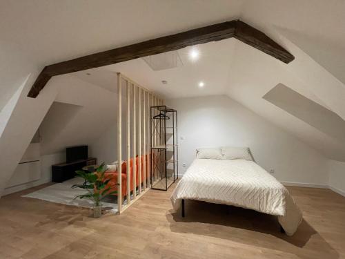une chambre avec un lit dans un grenier dans l'établissement Edenly Stay, à Saint-Quentin