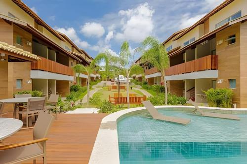 a view of the courtyard of a resort with a swimming pool at Imóvel Novo, 4 Quartos, Ar Condicionado em todos ambientes - Cond. Fechado - Guarajuba-BA in Camaçari