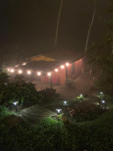 a house lit up at night with lights on it at El Barranquero cabaña La Tangara in Cali