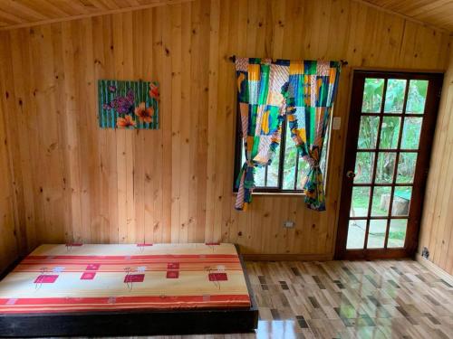 a bedroom with a bed in a wooden room at El Barranquero cabaña La Tangara in Cali
