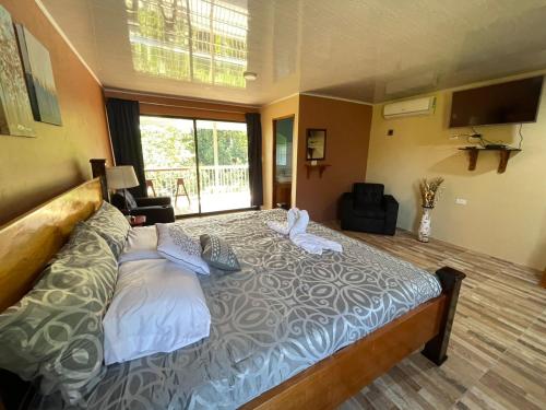 a bedroom with a large bed with a large window at Cabinas La Catarata in Fortuna