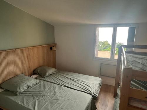 une chambre avec deux lits superposés et une fenêtre dans l'établissement L anse des Imperiales II, à Collioure