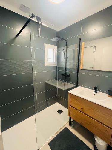 une salle de bain avec une douche en verre et un lavabo dans l'établissement L anse des Imperiales II, à Collioure