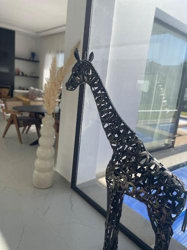 a statue of a giraffe in a living room at Villa Alanaé piscine chauffée in Douar Bellouk