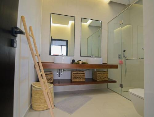 a bathroom with two sinks and two mirrors at Villa Alanaé piscine chauffée in Douar Bellouk