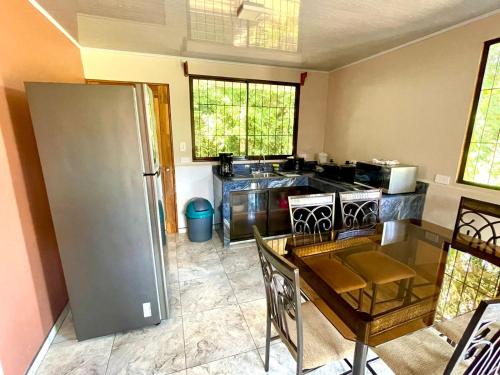 a kitchen with a stainless steel refrigerator and a table at Cabinas La Catarata in Fortuna