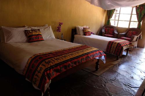 a bedroom with two beds and a window at Nsobe Game Camp in Masaiti