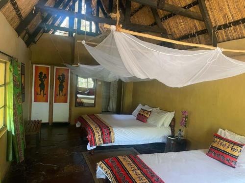 a bedroom with two beds and a mosquito net at Nsobe Game Camp in Masaiti