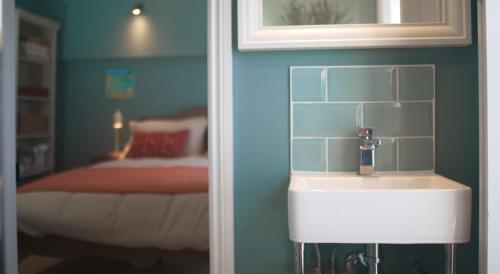 a bathroom with a sink and a bed in a room at The CLOUD Brockenhurst B&B in Brockenhurst