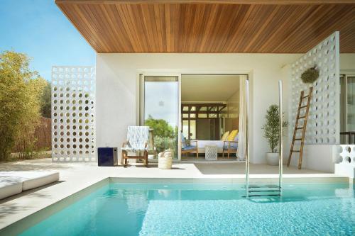 a house with a swimming pool and a patio at Inturotel Cala Esmeralda Beach Hotel & Spa - Adults Only in Cala d´Or