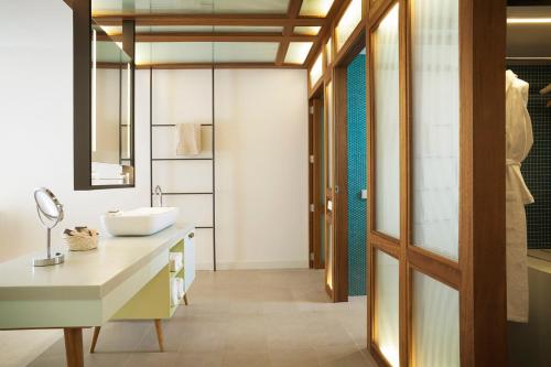 Inturotel Cala Esmeralda Beach Hotel & Spa - Adults Only في كالا ذاور: حمام مع حوض ومرآة