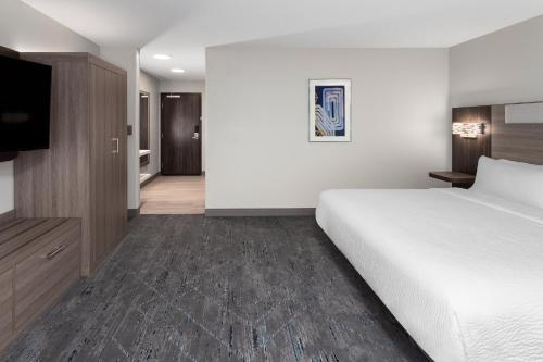 a hotel room with a bed and a flat screen tv at Holiday Inn Express & Suites Reedsburg - Dells Area by IHG in Reedsburg