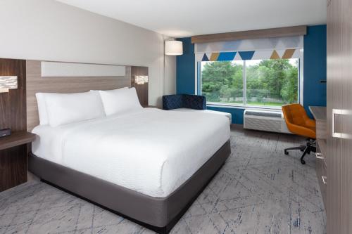 a bedroom with a bed and a desk and a window at Holiday Inn Express & Suites Reedsburg - Dells Area by IHG in Reedsburg