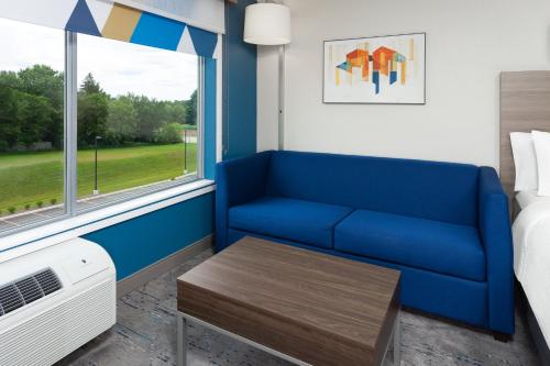 a living room with a blue couch and a window at Holiday Inn Express & Suites Reedsburg - Dells Area by IHG in Reedsburg