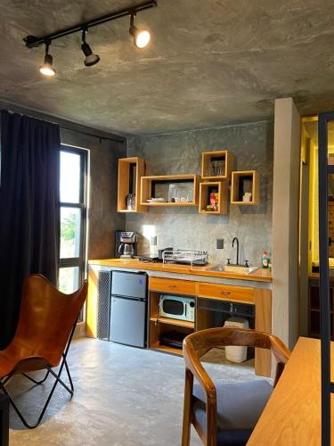 a kitchen with wooden cabinets and a table and chairs at Hotel Aeropuerto Tuxtla Gutierrez Ernesto Garcia in Chiapa de Corzo