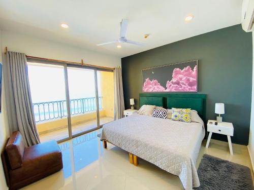 een slaapkamer met een bed en een groot raam bij Gavias Grand Cerritos in Mazatlán
