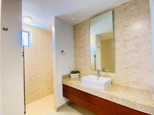 een badkamer met een wastafel en een spiegel bij Gavias Grand Cerritos in Mazatlán