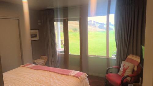 a bedroom with a bed and a large window at The Bluffs in Gibbston